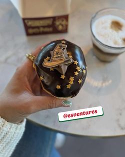Un beignet décoré d'un chapeau sorcier et étoile, accompagné d'un café.