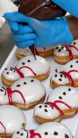 Des beignets décorés avec un glaçage et une garniture en chocolat au café Krispy Kreme.