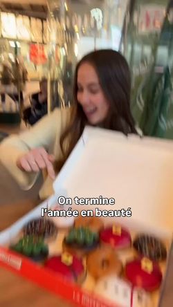 Dégustation de beignets colorés dans une boîte, idéale pour un petit-déjeuner ou un dessert.