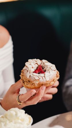 Doughnut aux amandes décoré de cerises et de sucre, parfait pour le petit-déjeuner ou comme dessert.