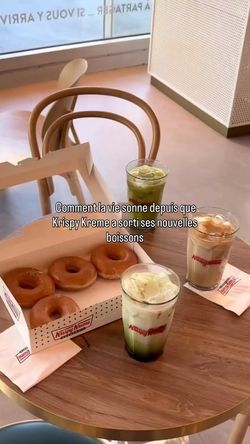 Doughnuts, iced coffee, and matcha drinks on a wooden table at Krispy Kreme - CC Vélizy 2 café.