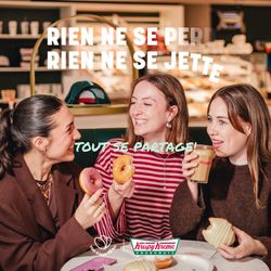 Trois personnes dégustent des doughnuts et du café dans un espace de pâtisserie Krispy Kreme, ambiance conviviale.