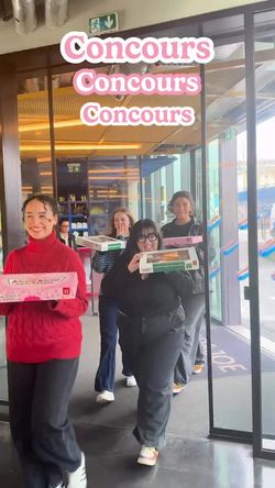 Group of individuals carrying boxes of doughnuts as they enter the café at Krispy Kreme - CC Belle Épine.