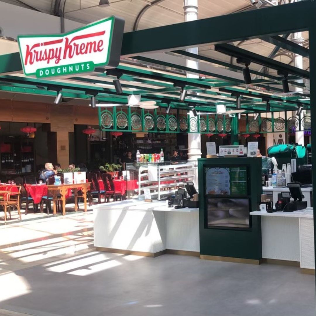 Krispy Kreme store featuring a bright, inviting design with doughnuts displayed, perfect for breakfast and dessert.
