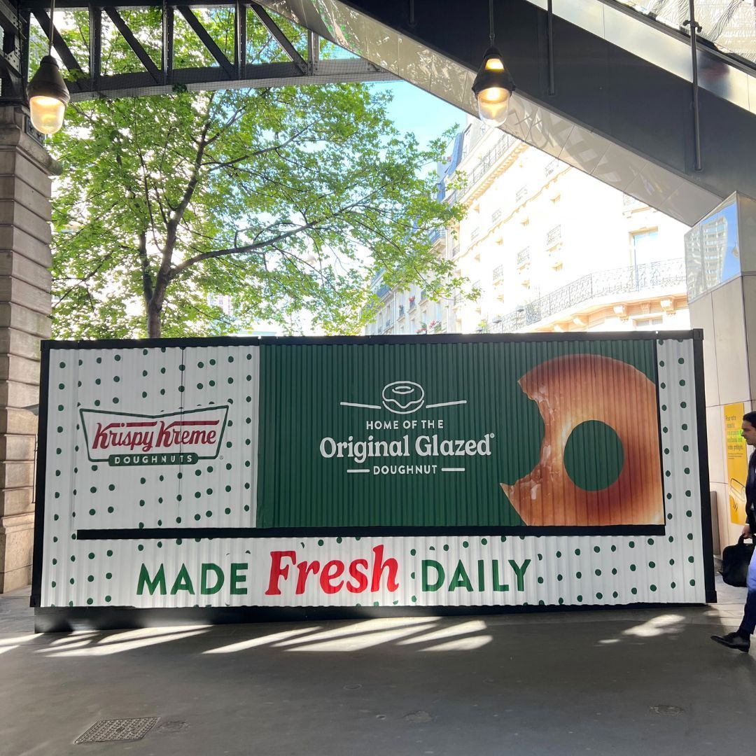 Krispy Kreme advertising Original Glazed doughnuts on a display. Freshly made daily.