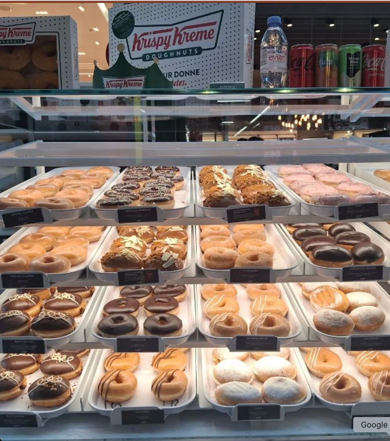 Display of assorted doughnuts at Krispy Kreme - Aéroville, featuring a variety of flavors and styles.
