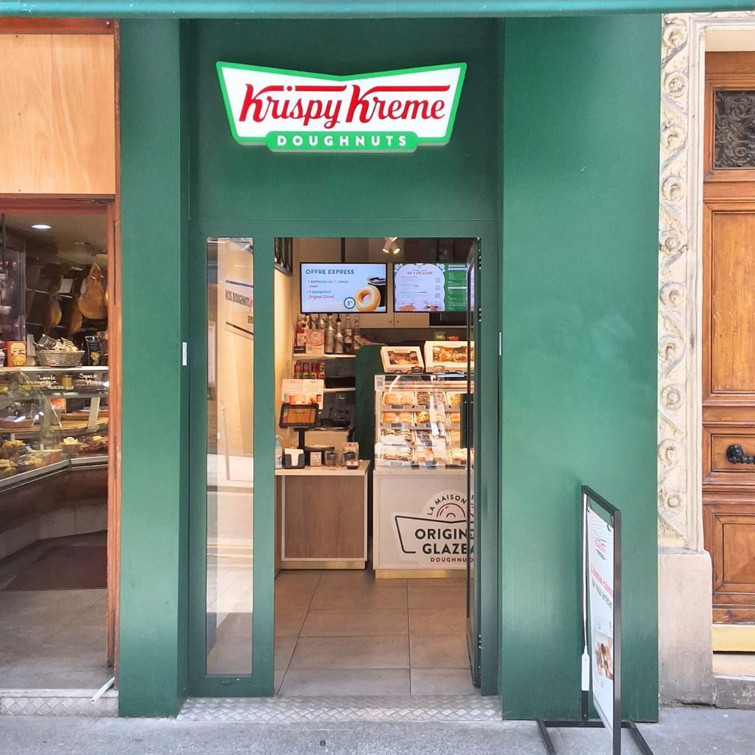 Entrée du café Krispy Kreme à Paris, offrant des doughnuts et des options de petit-déjeuner.