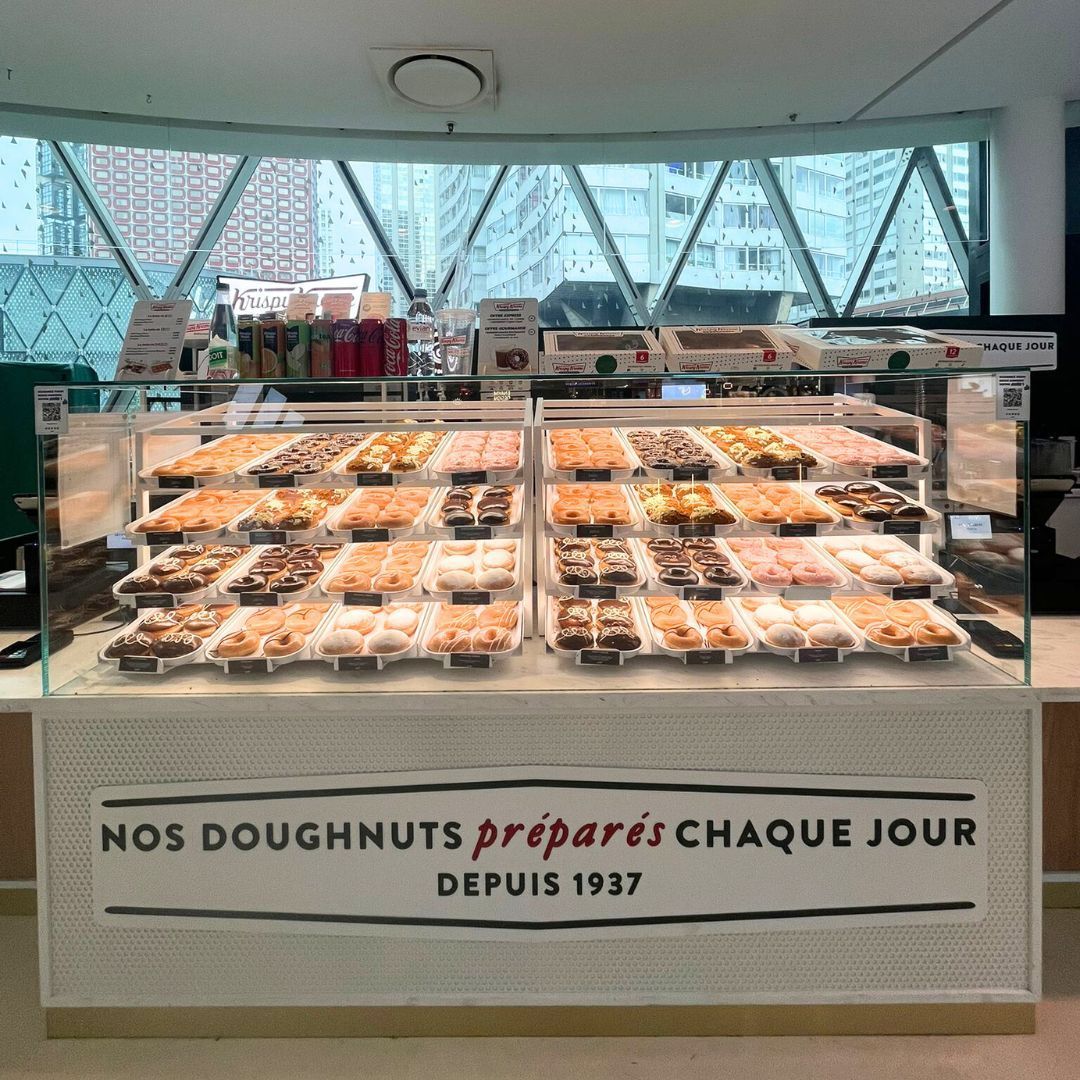 Vitrine avec une variété de doughnuts frais, préparés chaque jour chez Krispy Kreme.