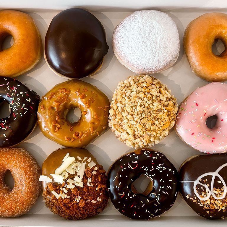 Une sélection variée de doughnuts glacés, fourrés et enrobés de sucre, parfaits pour un café ou un dessert.
