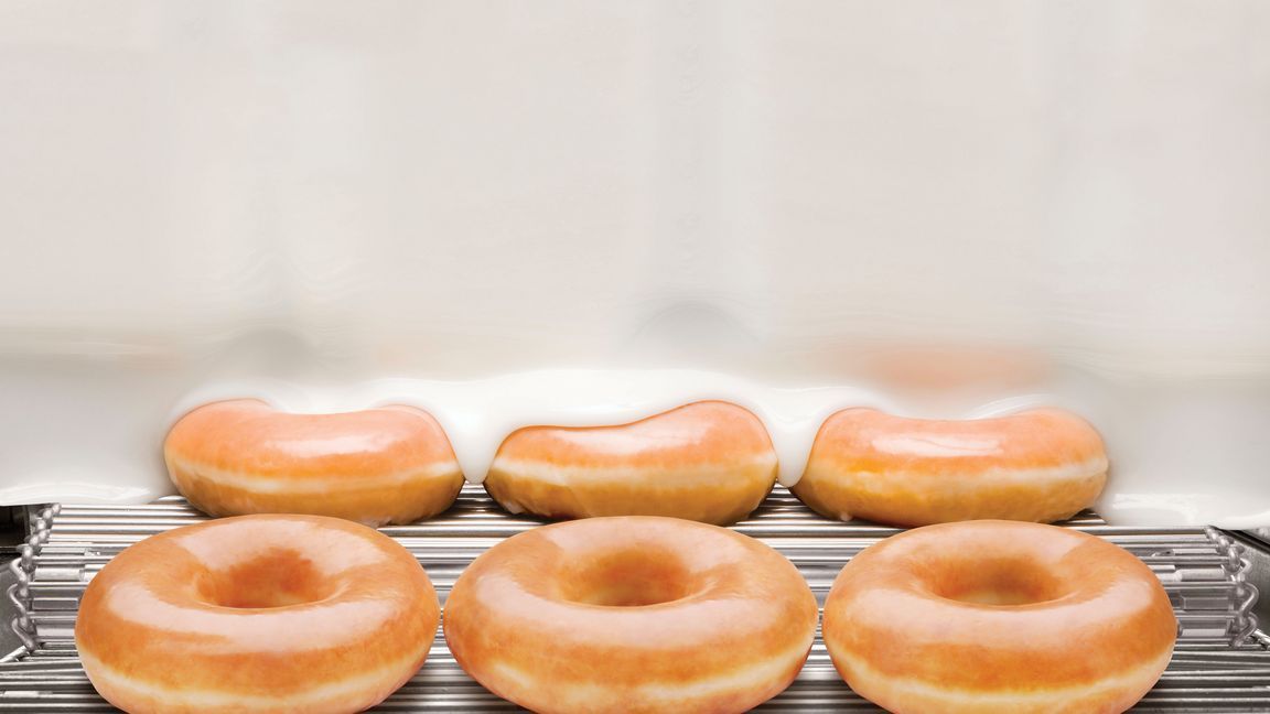 Doughnuts glacés sur une grille, prêts à être servis au café et à emporter.